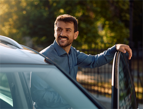 Noleggio auto a lungo termine Arval: un uomo sorride mentre entra in macchina